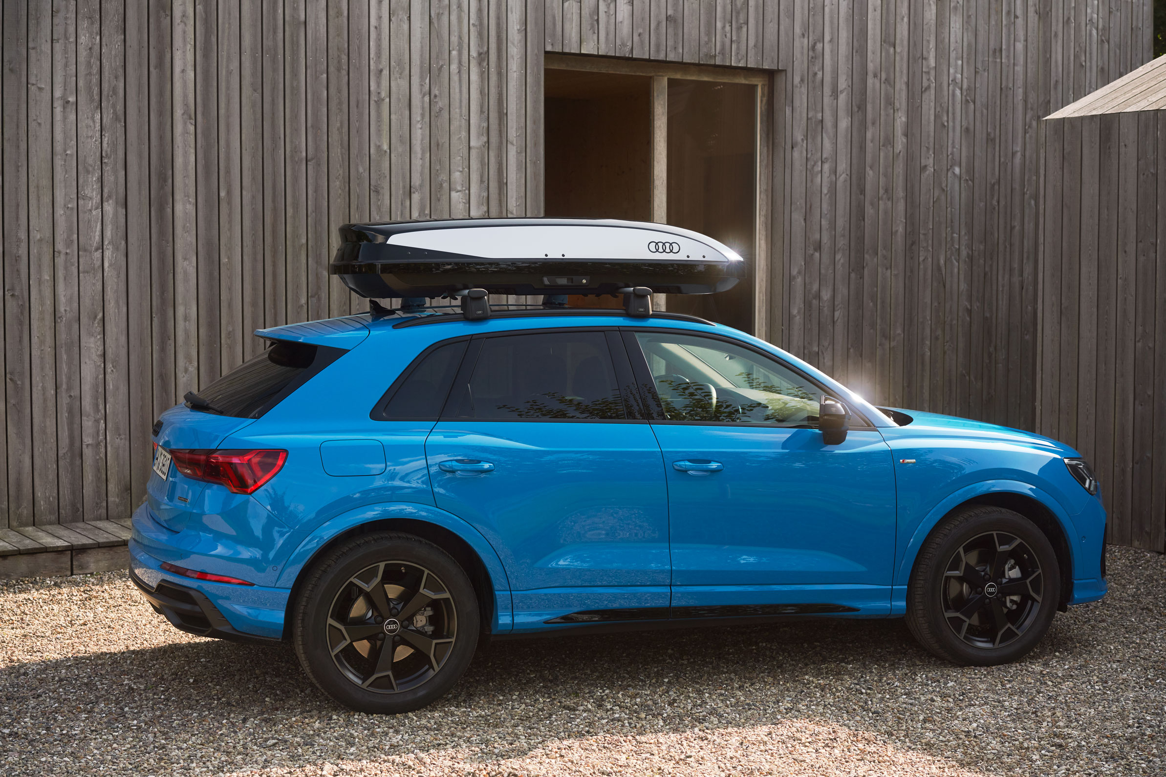 Ein Mann belädt die Dachbox eine Audi