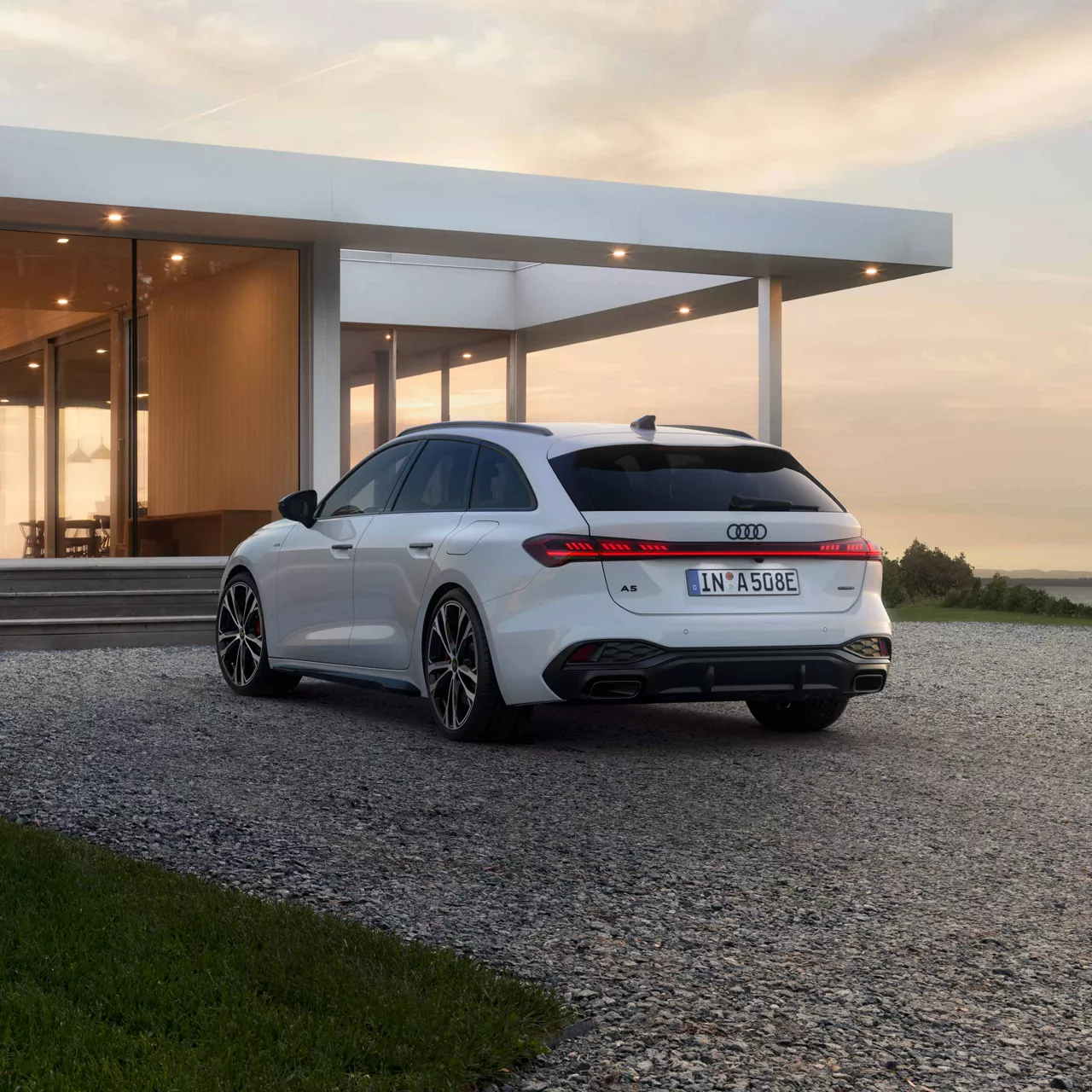 Audi A5 Avant e-hybrid Heckansicht vor einem Haus