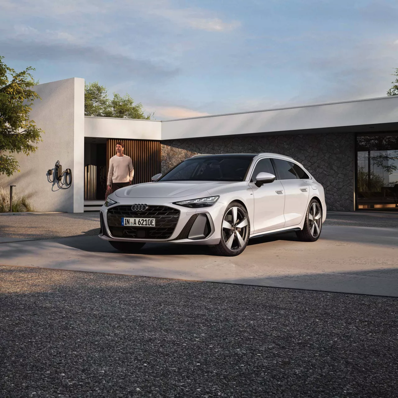 Audi A6 Avant e-hybrid parkt vor Wohnhaus mit Ladestation