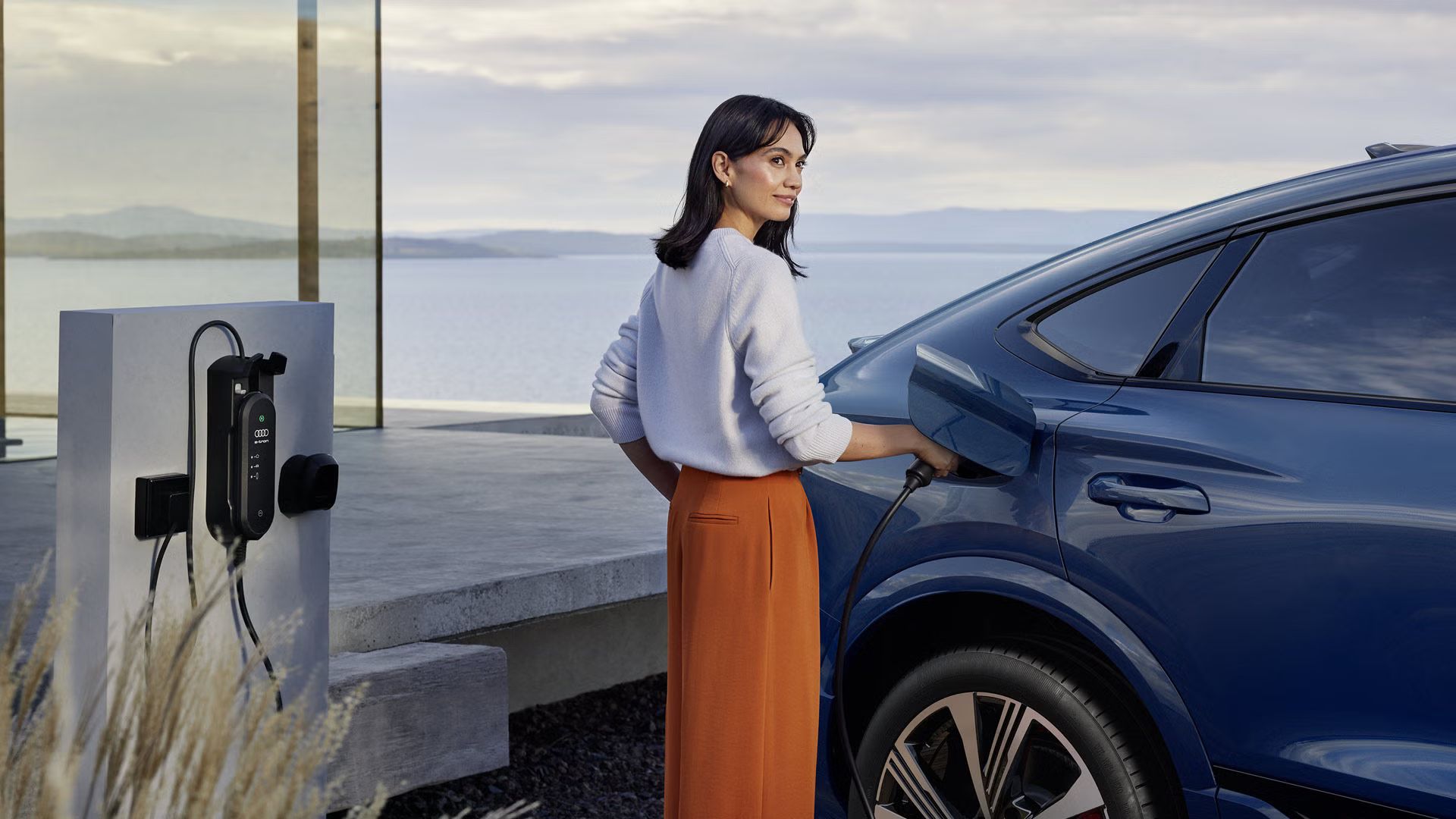 Ženska z elektriko polni vozilo Audi