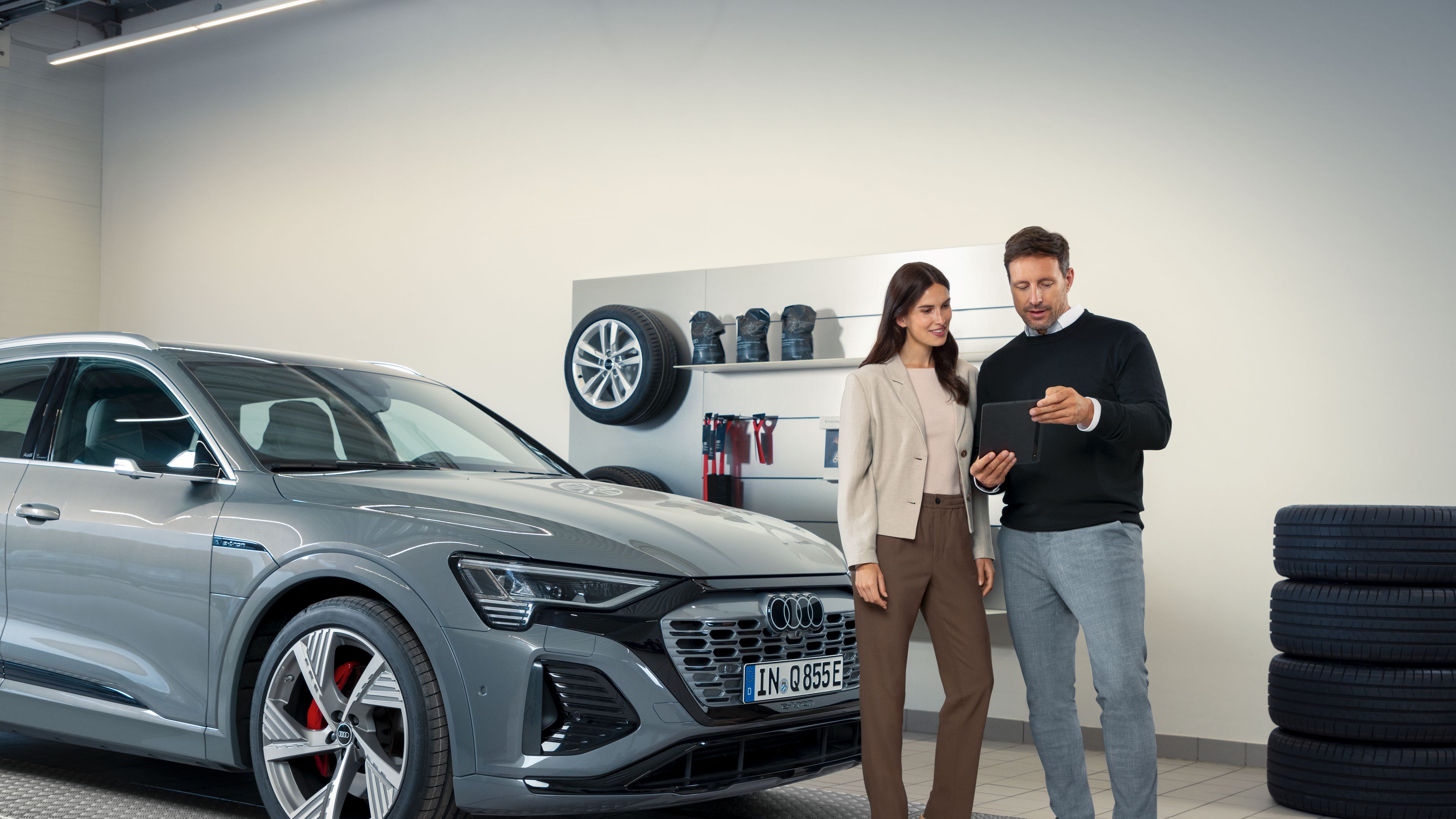 Service advisor with customer infront of Q8 e-tron in the direct reception