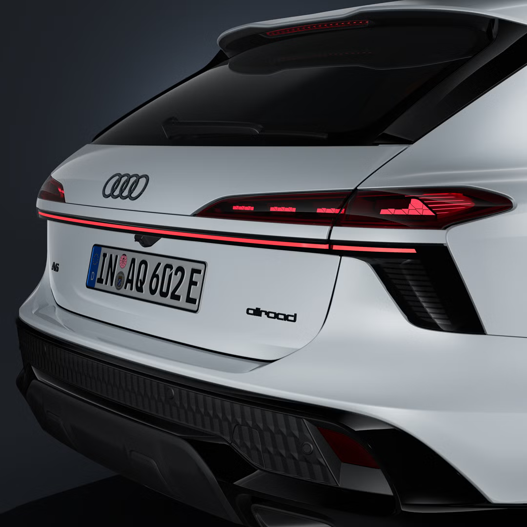 Poševni bližnji posnetek zadnjega dela Audija A6 allroad e‑hybrid z zadnjimi lučmi in svetlobnim trakom.