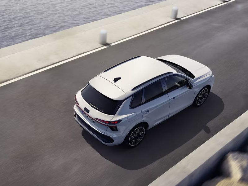 Der Q3 SUV e-hybrid fährt auf einer Straße parallel zum Meer. 	