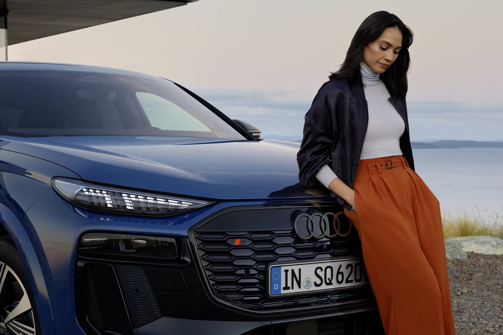 Ženska je naslonjena na vozilo Audi SQ6 Sportback