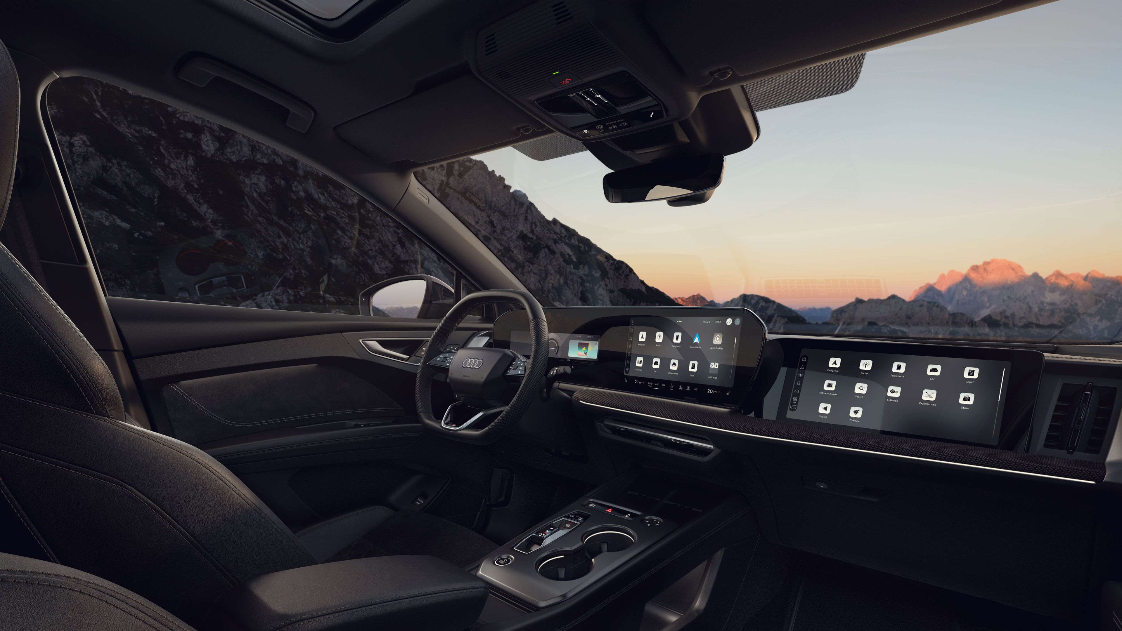 Notranjost Audi Q4 e-tron  z usnjenimi sedeži, ambientalno osvetlitvijo in velikim digitalnim zaslonom na armaturni plošči. Voznikov in sovoznikov sedež sta prostorna, med njima je eleganten sredinski konzol z minimalističnimi upravljalniki. Skozi velika okna in stekleno streho se vidi gorata pokrajina ob sončnem zahodu.
