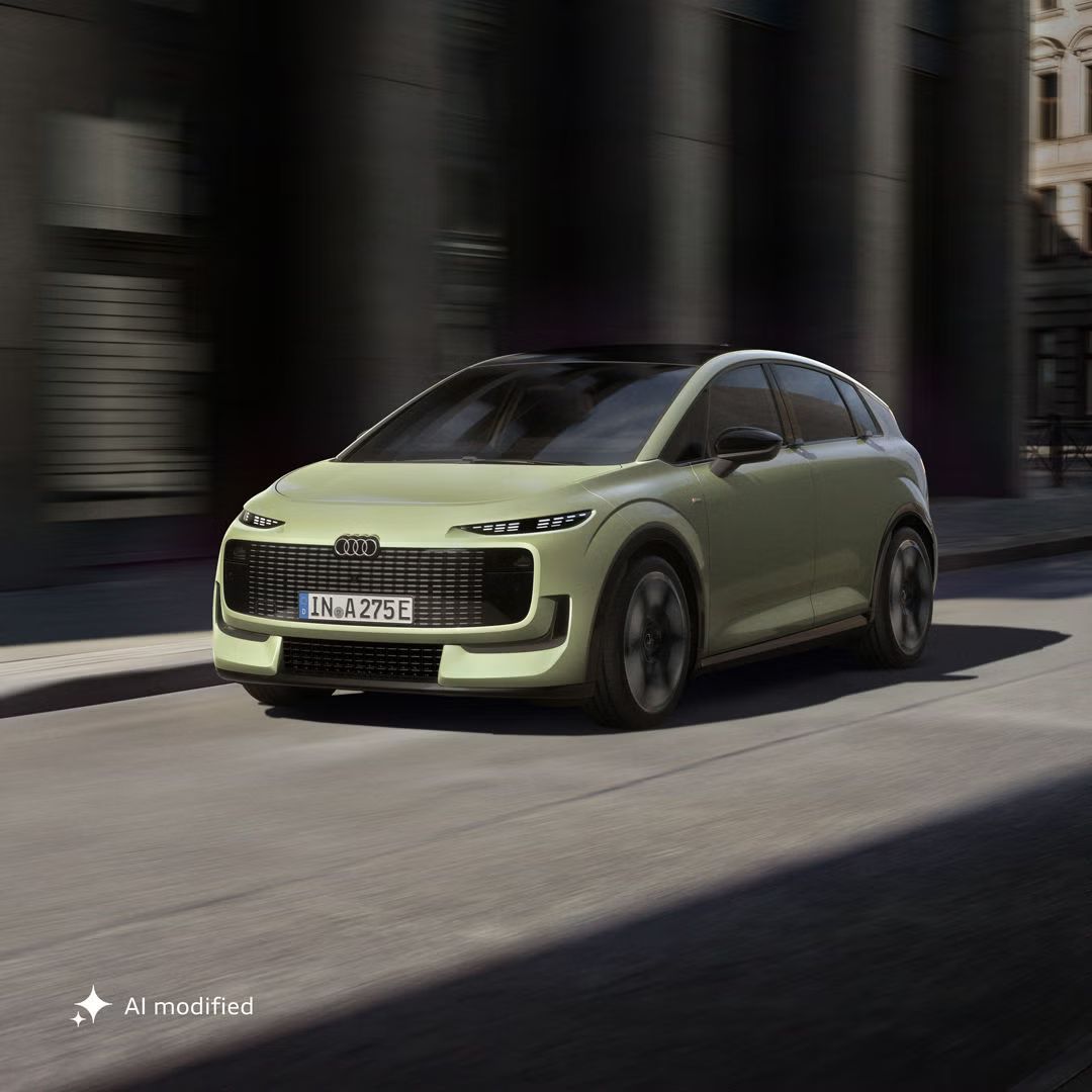 Stranski sprednji del modela Audi A2 e-tron na ozki cesti v urbanem okolju.