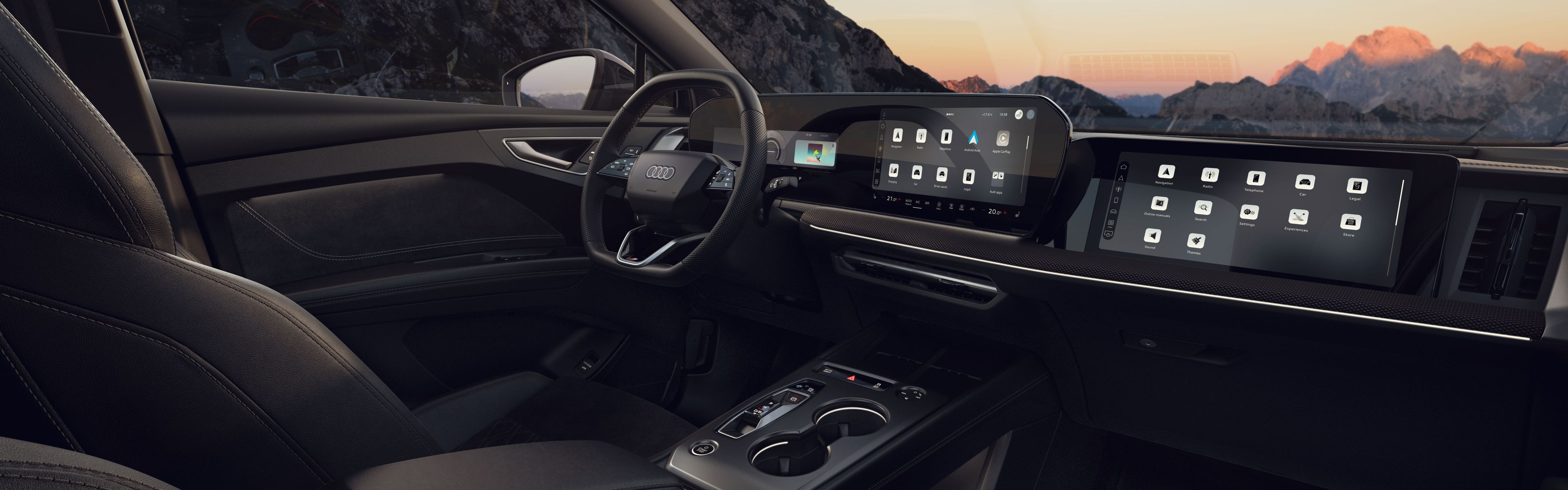 Notranjost Audi Q4 e-tron  z usnjenimi sedeži, ambientalno osvetlitvijo in velikim digitalnim zaslonom na armaturni plošči. Voznikov in sovoznikov sedež sta prostorna, med njima je eleganten sredinski konzol z minimalističnimi upravljalniki. Skozi velika okna in stekleno streho se vidi gorata pokrajina ob sončnem zahodu.