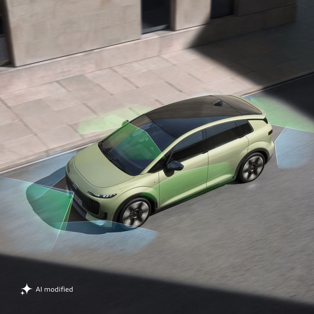Pogled od zgoraj na Audi A2 e-tron v ozki ulici. Sonce osvetljuje vozilo, medtem ko je del okolice v senci. Z zadnjega in sprednjega dela vozila se raztezajo zeleni in modri vektorji, ki razdeljujejo površina za vozilom in pred njim.