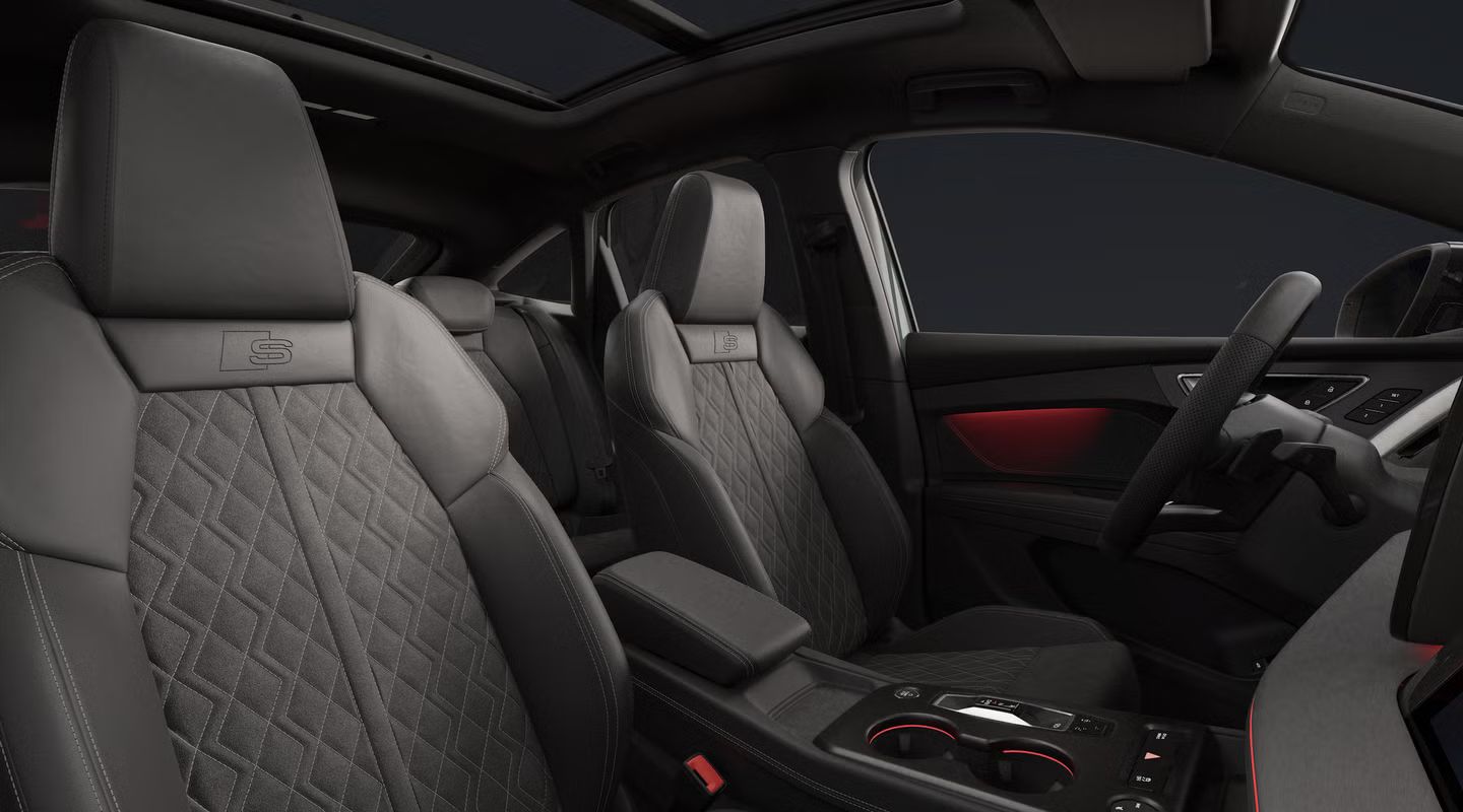 Pogled na notranjost modela Audi Q4 Sportback e-tron: voznikov prostor, sprednja sedeža in zadnja sedežna klop.