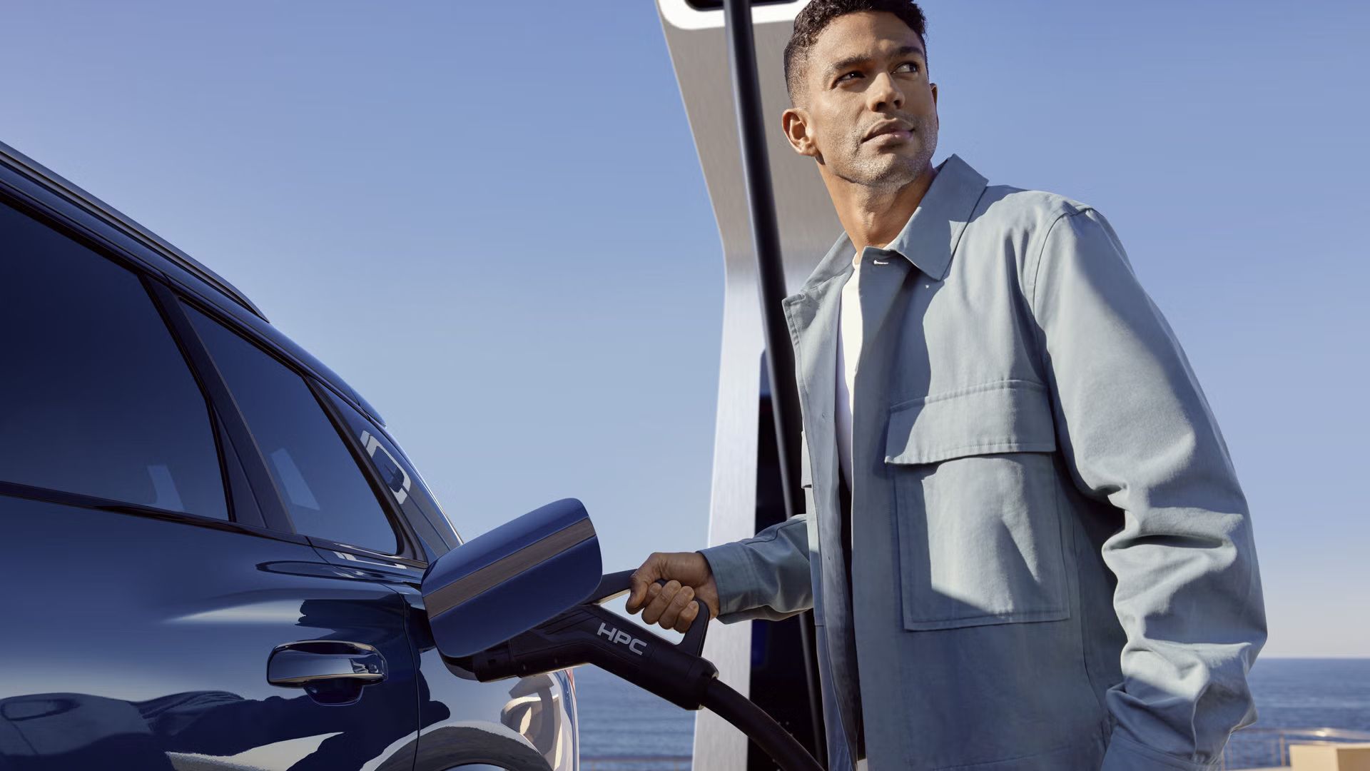 Moški z elektriko polni vozilo Q6 e-tron