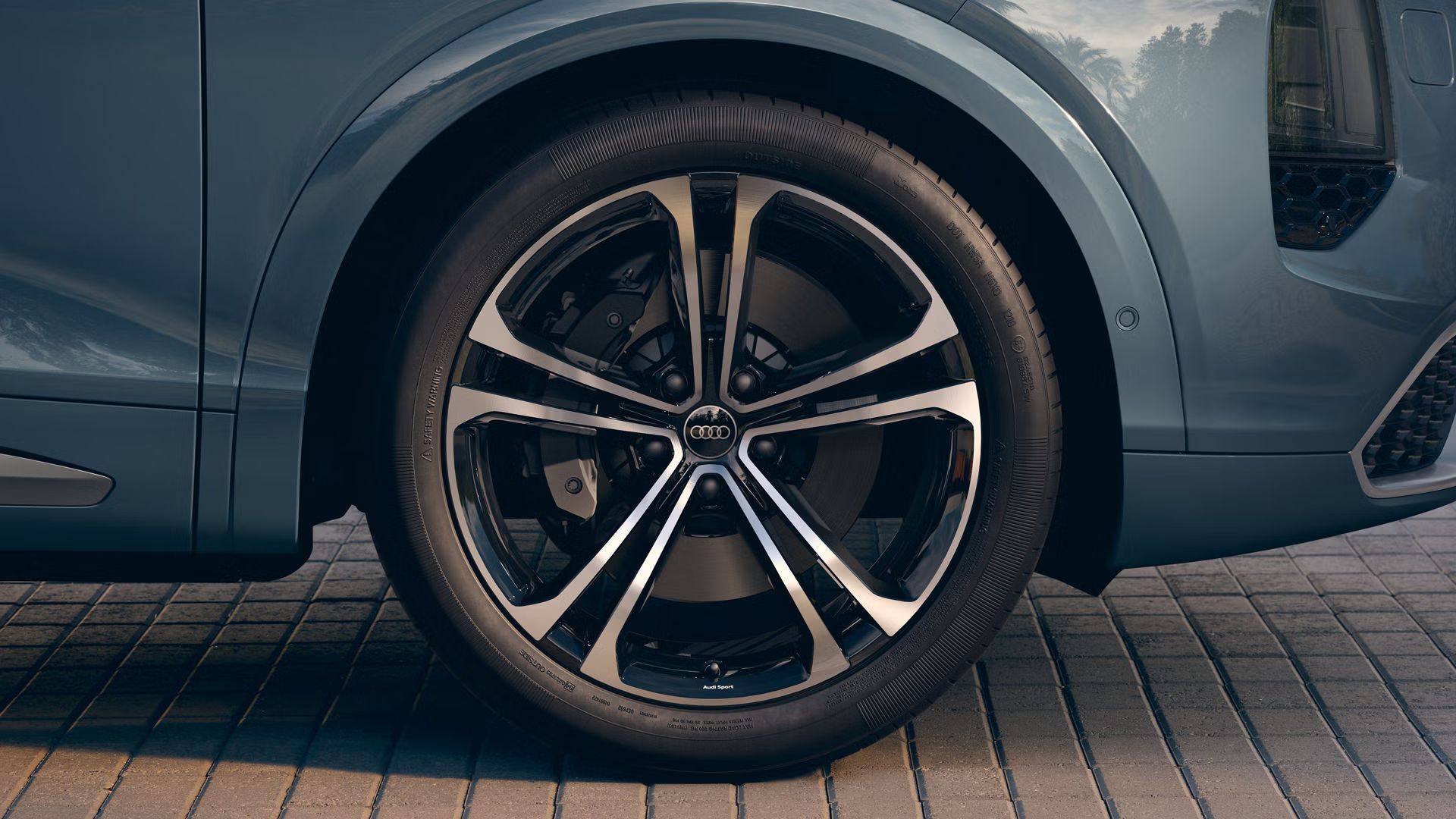 Bližnji posnetek 22-palčnega poliranega platišča iz lahke kovine Audi Sport z večkrakim S-designom črne kovinske barve.