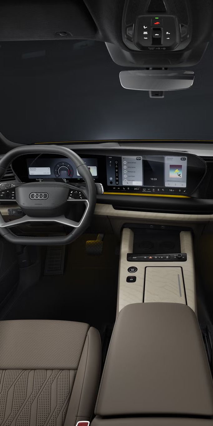 Notranjost Audi Q9 SUV z voznikovega pogleda prikazuje digitalni instrumentni zaslon, širok osrednji zaslon na dotik, večfunkcijski volan, sredinsko konzolo in ambientalno osvetlitev, ki poudarja sodoben in prestižen videz kabine.