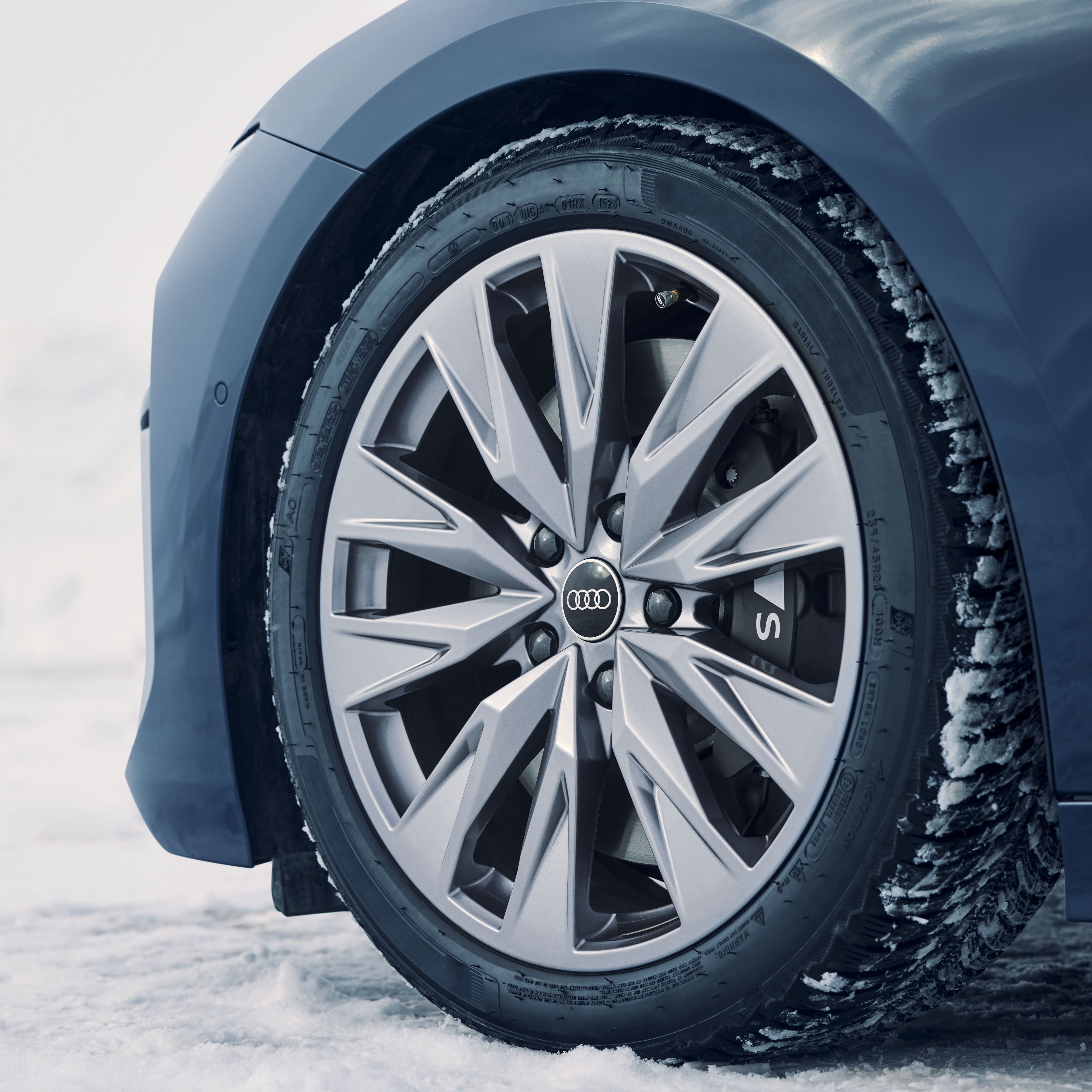Detajl sprednje leve pnevmatike vozila Audi S6 na snegu.