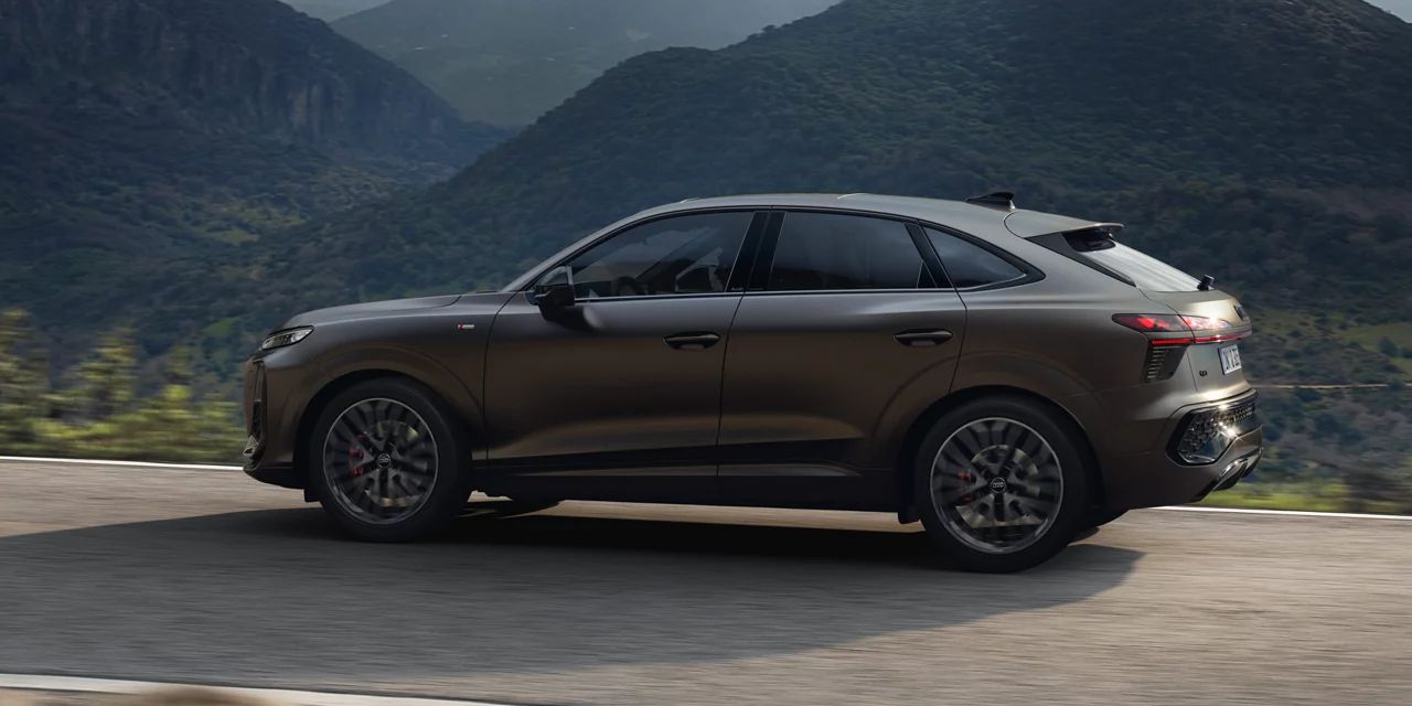 Rjavi Audi Q3 Sportback vozi skozi gorsko pokrajino. 