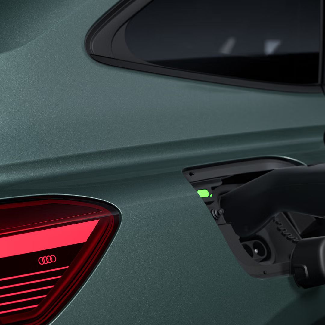 Bližnji posnetek od zadaj, na desni strani odprt napajalni priključek modela Audi Q4 Sportback e-tron.