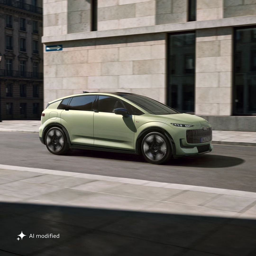 Stranski del vozila Audi A2 e-tron na cesti v urbanem okolju.