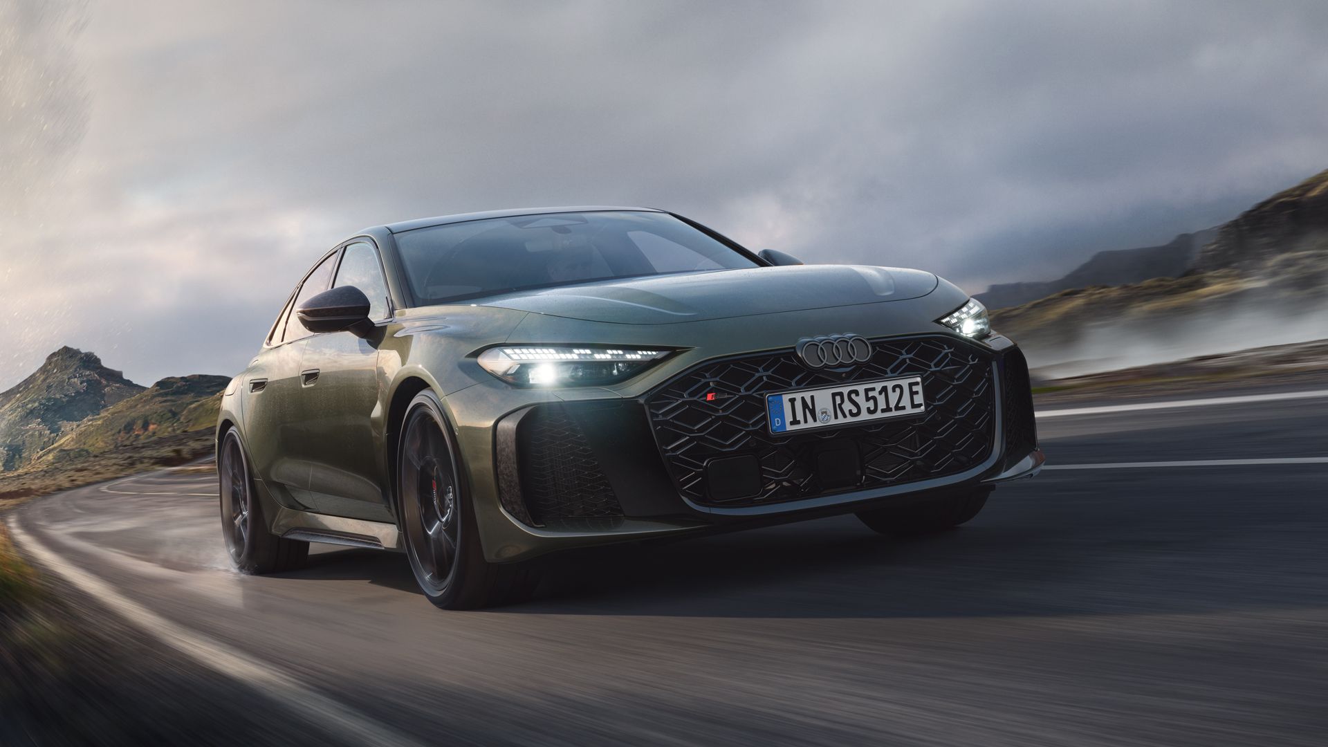 Die RS 5 Limousine schräg von vorn fährt auf einer Gebirgsstraße.