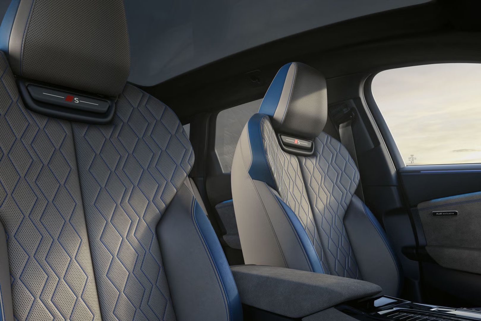 Notranjost Audija S6 Avant e-tron z dvema sprednjima športnima sedežema Audi exclusive, oblazinjenima v usnje v sivih in modrih odtenkih z izrazitim geometrijskim vzorcem. Sedeža imata integrirana naslona za glavo z oznako S, prostor pa deluje sodobno, prestižno in minimalistično, z mehko osvetlitvijo in panoramsko stekleno streho.