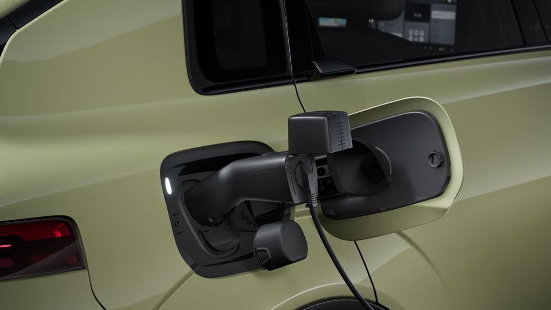 Bližnji posnetek desnega zadnjega dela vozila Audi A2 e-tron. Na odprtem napajalnem priključku je priključen električni kabel.