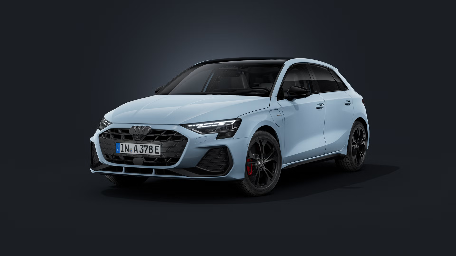 Audi A3 Sportback TFSI e, fotografiran iz sprednjega bočnega kota na temnem studijskem ozadju, z LED-žarometi, črnimi športnimi platišči in priključkom za polnjenje na sprednjem levem blatniku.